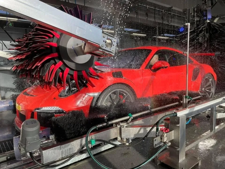 Rode Porsche tussen de borstels van de wasstraat