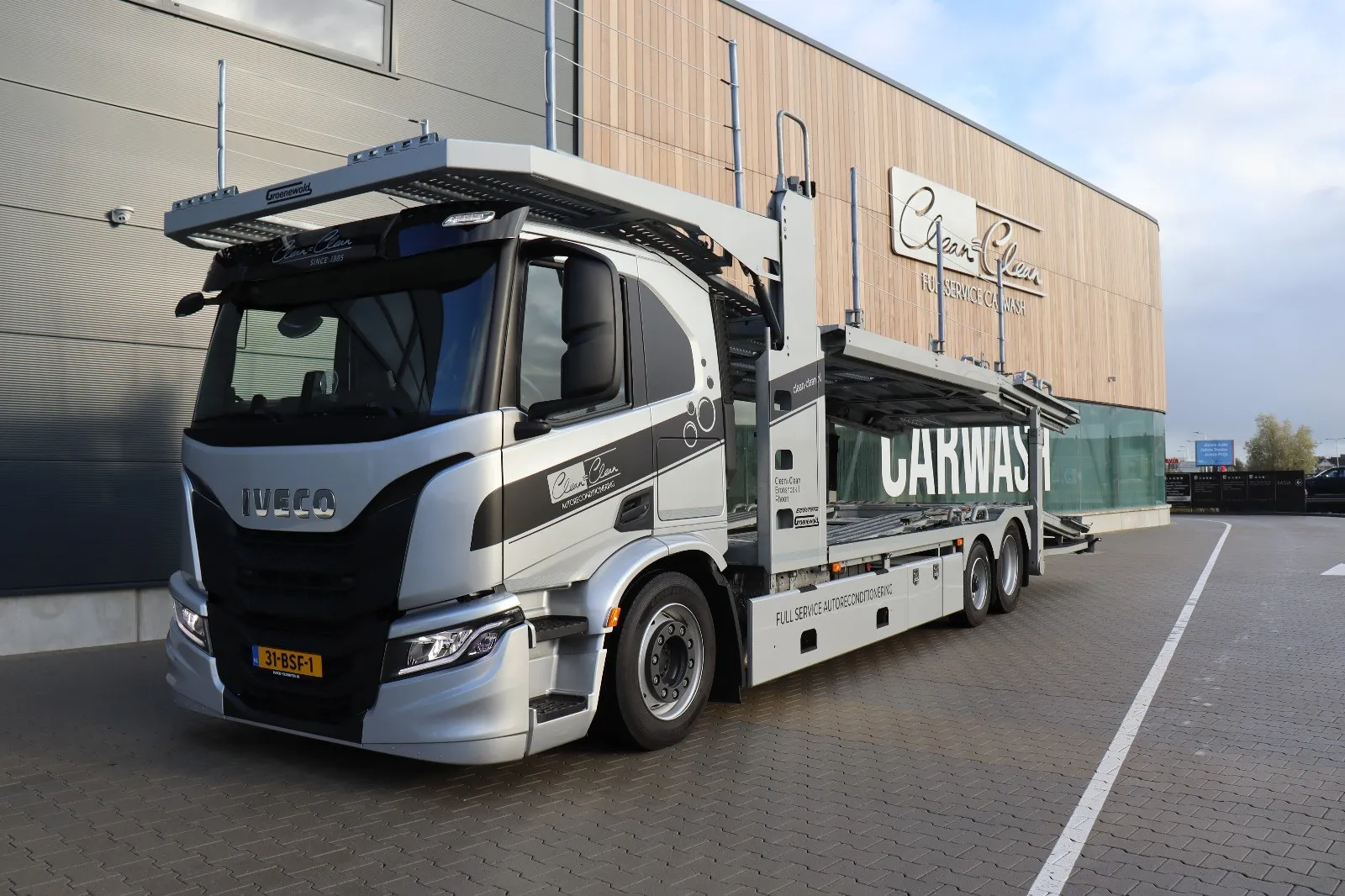 Autotransporter van Clean = Clean voor het pand